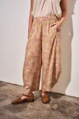 Babucha fluida de tiro alto con cintura elástica, diseño de rayas combinadas con estampado tipo toile de jouy en tonos beige y rojo.