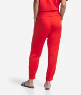 Pantalón jogger color naranja, de tiro medio, con cintura elastizada, lazo ajustable, pliegues delanteros y bolsillos laterales.