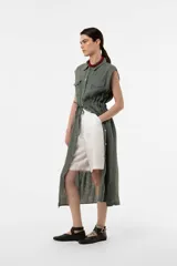Vestido camisero midi sin mangas color verde militar, confeccionado en lino, con botones frontales, bolsillos en el pecho y cintura ajustable con cordón.