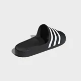 Sandalias tipo chinela Adidas Adilette, color negro con las tres bandas características de la marca en color blanco sobre la banda superior. Presentan una plantilla contorneada y suela de poliuretano.