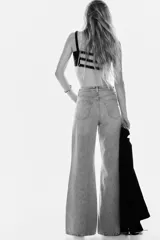 Jeans de cinco bolsillos en denim de algodón rígido, color gris claro lavado. Presenta un corte de cintura ultra alta, pierna amplia y recta desde la cadera hasta el bajo, con un estilo levemente largo.