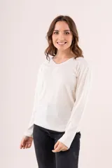 Camiseta blanca de manga larga con escote en V y detalle bordado en el centro del pecho.