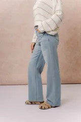 Pantalón de jean tiro alto con calce wide leg, color celeste claro con lavado suave y detalle de desgaste en el bolsillo delantero.
