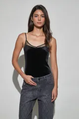 Body de terciopelo negro con escote en V y detalles de encaje transparente en la parte superior. Presenta breteles finos ajustables.