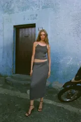 Falda midi de tiro alto con cintura elástica, confeccionada en tejido de punto con aplicación de hilo metalizado a contraste.