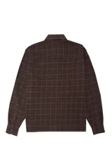 Camisa de corte boxy confeccionada en franela a cuadros, con cuello clásico, cierre frontal de botones, bolsillo en el pecho y puños abotonados.
