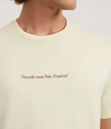 Remera color crema de algodón, corte clásico, con cuello redondo y mangas cortas. Estampa frontal con la frase "Nascido num País Tropical".