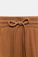 Pantalón cargo de tiro medio con efecto lavado, confeccionado en algodón. Presenta cintura elástica ajustable con cordones, bolsillos laterales y bolsillos de plastrón con solapa en las piernas. Diseño de pierna recta con combinación de tejidos a tono.