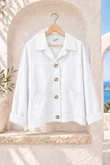 Chaqueta de gabardina blanca con botones marrones contrastantes, bolsillos frontales grandes y mangas largas con vuelta.