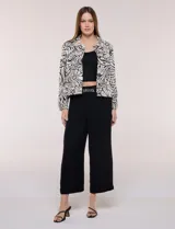 Camperita liviana de silueta entallada y largo a la cintura, con cuello camisero, cierre frontal de botones, mangas largas y bolsillos con solapa en el pecho. Presenta estampado animal print.