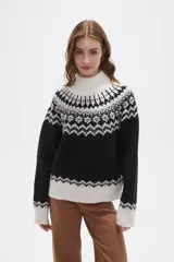Sweater de punto con diseño jacquard en cuello, puños y ruedo. Presenta cuello alto, mangas largas y corte holgado.