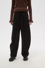 Pantalon de vestir negro de calce alto, con diseño barrel leg y pinzas frontales.