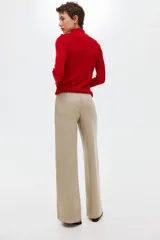 Pantalón de punto pesado color beige con acabado cepillado suave, de piernas rectas, cintura elástica y bolsillos delanteros tipo parche con botón.