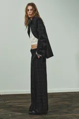 Pantalón de tiro alto con diseño de cuadros, pernera recta y cintura con trabillas. Cuenta con bolsillos laterales, bolsillos de vivo en la parte posterior y cierre frontal con cremallera, botón oculto y gancho metálico.