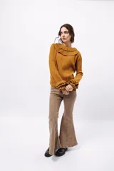 Buzo de tejido acanalado color lila, con cuello redondo decorado con dos volados y mangas largas con tres volados pequeños en los puños.