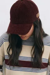 Gorro tipo cap de pana en color bordó, con detalle de etiqueta de cuero en el lateral.
