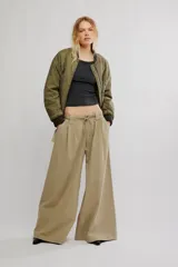 Pantalón chino de tiro bajo, color negro, pierna muy ancha, con cintura elástica con cordón ajustable y pinzas en la parte superior.