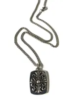 Collar con dije rectangular de aleación de cobre y zinc con acabado envejecido y diseño de cruz ornamentada. Incluye cadena de eslabones de acero inoxidable.