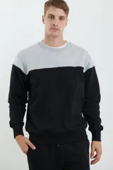 Sweater deportivo de hombre con escote redondo, diseño colorblock con la parte superior en gris claro y el cuerpo y mangas en negro. Presenta puños y cintura elastizados.