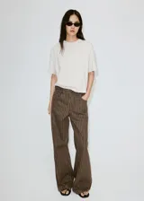 Jeans de corte recto y tiro medio, confeccionados en denim marrón con diseño de rayas verticales claras. Presenta bolsillos delanteros y traseros clásicos.