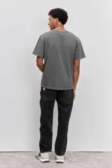 Remera de algodón color marrón con efecto lavado, de corte clásico y cuello redondo. Presenta un pequeño bordado de un pájaro en el pecho.