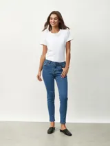 Jean ajustado de mezclilla azul medio, tiro medio/alto, con corte skinny.