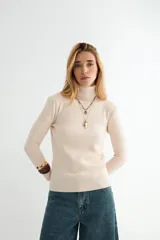 Polera de cuello alto y manga larga, confeccionada en tejido de punto fino con puños y ruedo acanalados.