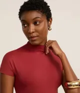 Body manga corta color borgoña, con cuello redondo medio y cierre inferior.