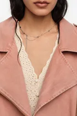 Chaqueta de corte globo color salmón, confeccionada en algodón lavado. Presenta cierre frontal con cremallera, cuello con solapas grandes, mangas largas con puños ajustables, bolsillos laterales y calce holgado.