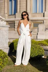 Mono largo color crudo, con breteles finos, escote en V, lazo en la cintura, bolsillos laterales y corte holgado.