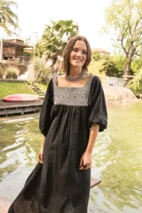Túnica de lino color crudo con corte holgado y mangas abullonadas con elástico. Presenta una pechera frontal y trasera con estampado étnico en tonos terracota y amarillo.