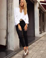 Botinetas estilo western de caña baja, confeccionadas en una combinación de cuero liso y gamuza en tonos marrón oscuro, marrón medio y crema. Presentan cierre lateral, taco bajo cuadrado y diseño con recortes característicos del estilo cowboy.