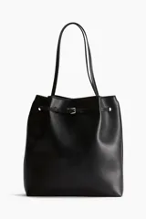 Bolso negro tipo shopper con doble asa larga y ajuste superior con cordón y hebilla.