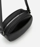 Cartera tipo camera bag marca Satinato de color negro, con forma ovalada, superficie texturizada, cierre superior con cremallera y correa ajustable.