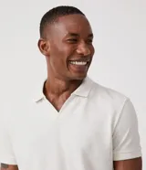 Polo de manga corta color verde salvia, con cuello polo y escote en V con borde de punto contrastante. Presenta una textura tejida sutil.