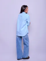 Camisa de manga larga a rayas verticales celestes y blancas, de corte suelto, confeccionada en algodón.