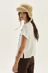 Remera blanca de algodón con cuello redondo y manga corta. Presenta un estampado central con dos unicornios enfrentados rodeados de follaje y el texto "MAGICAL DREAMS".