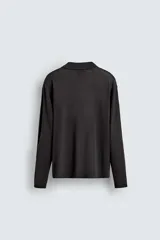 Polo de punto de manga larga con cuello solapa y abertura frontal, confeccionado en tejido de viscosa con acabado en rib.