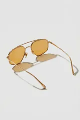 Lentes de sol Horizon de diseño geométrico con armazón metálico dorado y cristales en tonos amarillos.