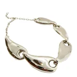 Collar corto plateado con cadena de eslabones y dijes con forma de gota.