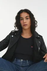 Campera negra de cuero sintético, estilo biker, con cierre cruzado y múltiples bolsillos con cremallera.