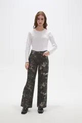 Pantalon de jean de corte ancho y tiro bajo, con estampado abstracto en tonos oscuros.