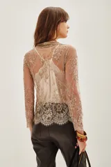 Saco de encaje con diseño floral y detalles bordados en hilo dorado. Presenta mangas tres cuartos, escote en V y bordes con terminación de puntilla. El diseño es abierto al frente con una estructura delicada y elegante.