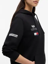 Buzo con capucha y cordón ajustable, confeccionado en algodón. Presenta un diseño de corte regular con bolsillo tipo canguro, puños y bajo de punto canalé. Incluye logos de la colaboración Cadillac Formula 1 Team y Tommy Hilfiger en el pecho, además de detalles distintivos en la manga y la nuca.