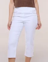 Capri blanco de corte ajustado, con tiro alto y pretina ancha elastizada tipo faja. Presenta bolsillos falsos al frente con remaches, piernas entalladas con pequeñas aberturas en los laterales y ruedo desflecado.