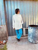 Sweater tejido en lana color crudo, con cuello alto, corte holgado y bordado a mano en color rojo con la frase "Life Walker" en la espalda.