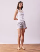 Conjunto de pijama de dos piezas marca René Rofé, compuesto por un top blanco de breteles finos y un short gris con rayas horizontales blancas, cintura elastizada y cordón de ajuste.