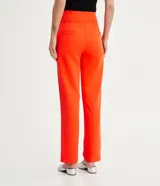 Pantalón de vestir color naranja, de corte recto y tiro alto, con bolsillos laterales y cierre frontal con cremallera.
