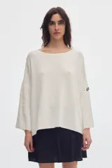Sweater de punto color blanco crudo, con cuello bote y mangas evasé de corte amplio y holgado.