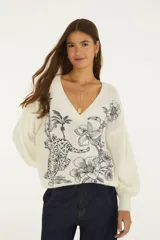 Sweater blanco de tejido de punto con escote en V, mangas largas y estampado ilustrado de inspiración tropical con flores y un leopardo en color negro.